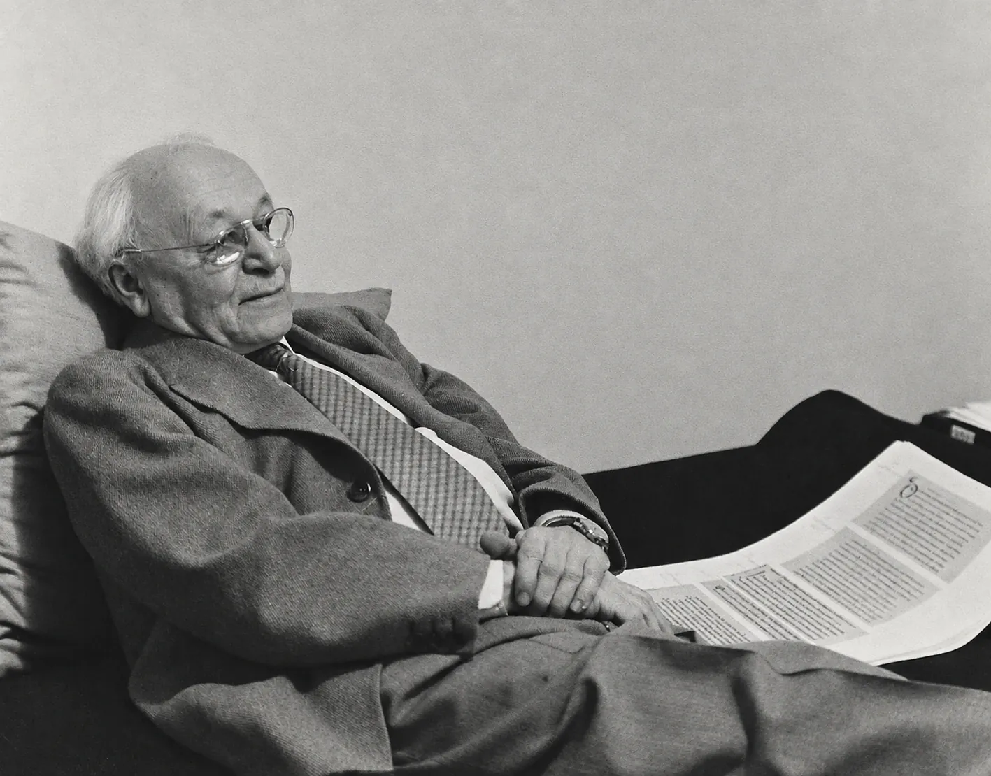 Elias Avery Lowe, auf einem Sofa zurückgelehnt, neben ihm eine großformatige Handschriftenreproduktion