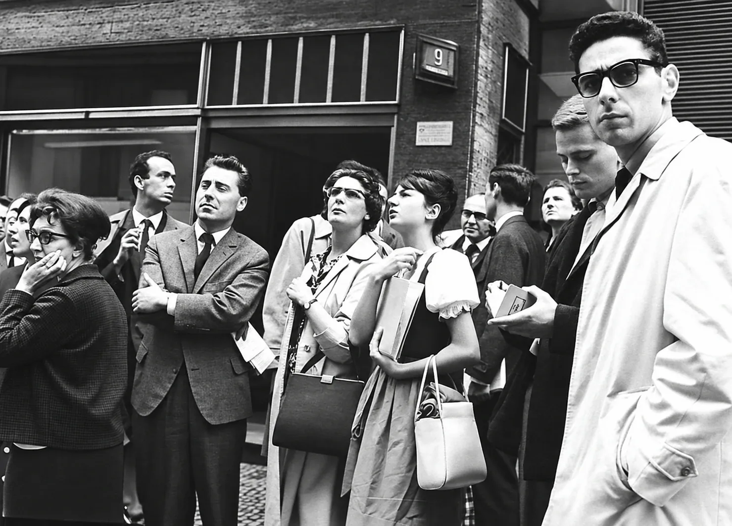Gruppe von Studentinnen und Studenten auf einer Straße, den Blick nach oben gerichtet